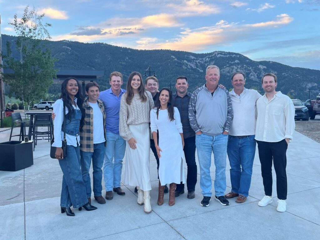 Erben Associates team members pose for a photo together with mountains in background